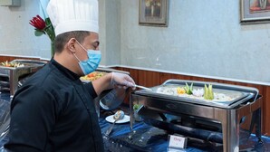 A buffet setup with various food items and a person serving. - Maidan Al Bait (Makkah)