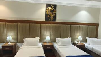 Habitación cuádruple Deluxe, vista a la ciudad | Sábanas de algodón egipcio, ropa de cama de alta calidad y minibar