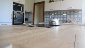 Una cocina con encimera de madera, un hervidor y una cuchara.