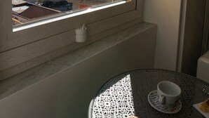 Een balkon met een tafel, een kopje en een croissant.