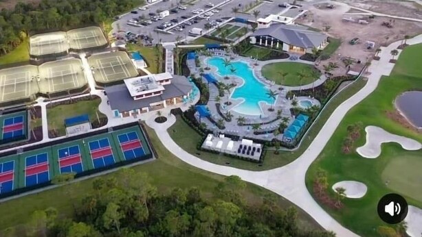 Luftaufnahme eines Resorts mit großem Schwimmbad, Tennisplätzen und Golfplatz.