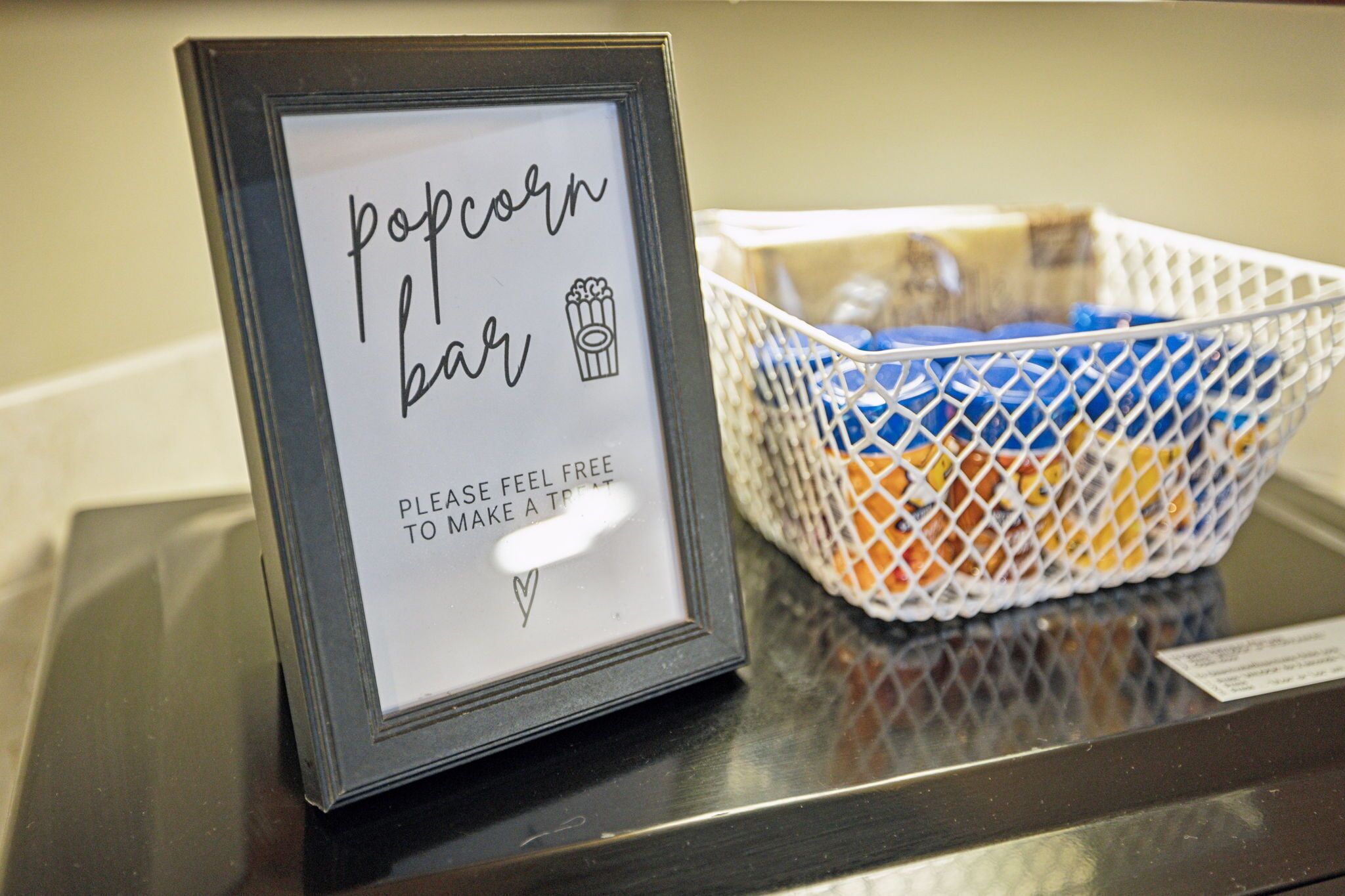 Een lijst met de tekst 'popcorn bar' en een popcorn icoon, geplaatst naast een mand vol popcorn.