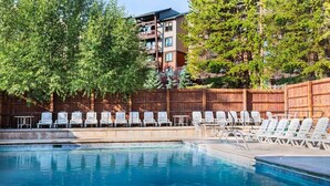 Une piscine avec des chaises longues et une clôture en bois.