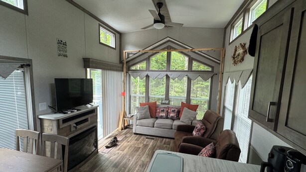 A spacious living area with a television, seating, and a dining table. - Cozy 1 1/2-bedroom, 4 Bed Tiny House with Gas Heat/AC, WiFi ATV/Snowmobile (Park Falls)