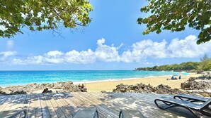 A wooden deck with two chairs facing a beach. - Hispaniola Beach 2-Bdrm 1st floor Condo with Oceanview & Private Beach in Sosúa (Sosúa)