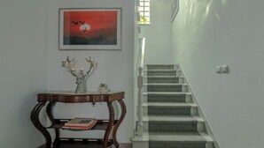 A staircase with a carpeted landing and a framed picture above it. - Apartment with terrace in Estoril seaside villa (Estoril)