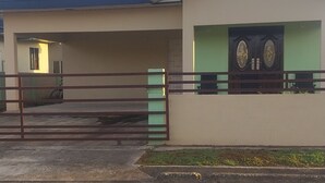 A two-story building with a flat roof and a green door. - Charming 1-bedroom house with AC, WiFi in peaceful St. Helena Village Piarco (St helena village piarco)