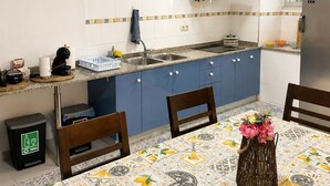Una cucina compatta con mobili blu, una cappa in acciaio inossidabile e uno schienale piastrellato.