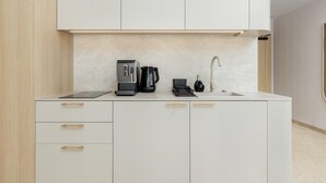 A modern kitchen with a built-in coffee maker, a kettle, and a sink. - Apartment Close to the Beach, With Pool (Dziwnów)
