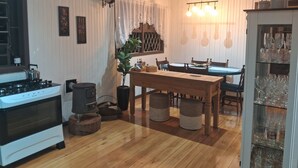 A cozy kitchen with a stove, oven, and dining table with chairs. - Cozy house in the mountains (Centro Canela)
