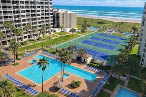 Un hôtel doté d’une piscine, de courts de tennis et offrant une vue sur la plage.