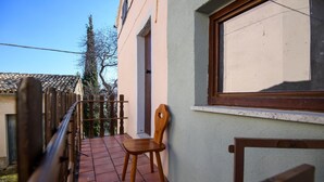 A balcony with a wooden chair, a wooden fence, and a building with a window. - 2 bedroom lovely home in Frontale (Frontale)
