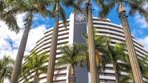 A hotel with a prominent star logo, surrounded by tall palm trees. - Luxury Apartment - Oracle Broadbeach  (Broadbeach)