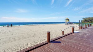 A beach with a wooden boardwalk leading to a lifeguard tower. - Luxury Apartment - Oracle Broadbeach  (Broadbeach)