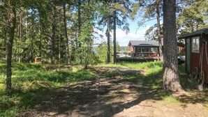 A dirt path leading to a rustic cabin with a wooden deck and a red roof. - 3 bedroom amazing home in Yxlan (Yxlan)