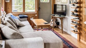 A cozy living room with a sectional sofa, a television, and a shoe display. - 3 bedroom amazing home in Yxlan (Yxlan)