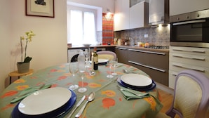A modern kitchen with a dining area set for four. - 1 bedroom cozy apartment in Roma (Roma)
