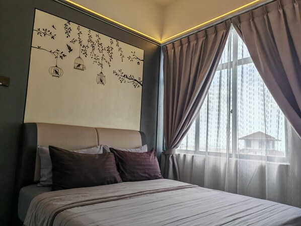A modern bedroom with a large bed, a wall-mounted artwork of birds and branches, and a view of a building through sheer curtains.