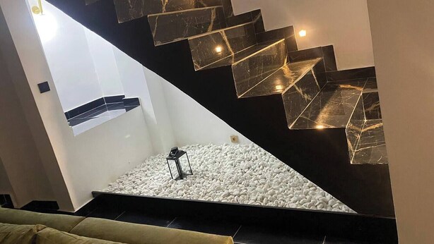 A modern staircase with black and white marble steps and a white pebbled base. - Villa Bijou in Abidjan (Abidjan)