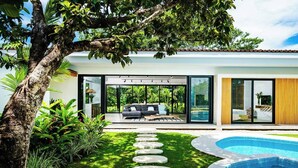 A modern house with a swimming pool, a patio with a sofa, and a garden with a stone pathway. - Luxury Modern Escape in Hacienda Pinilla: Beach Club Access & Endless Adventure! (Pinilla)
