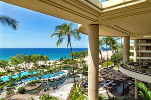A resort with a pool area, palm trees, and a view of the ocean. - Mauna Kea - Waiulaula Condo - Stunning Sunset and Sunrise Views - Close to Pool (Kamuela)