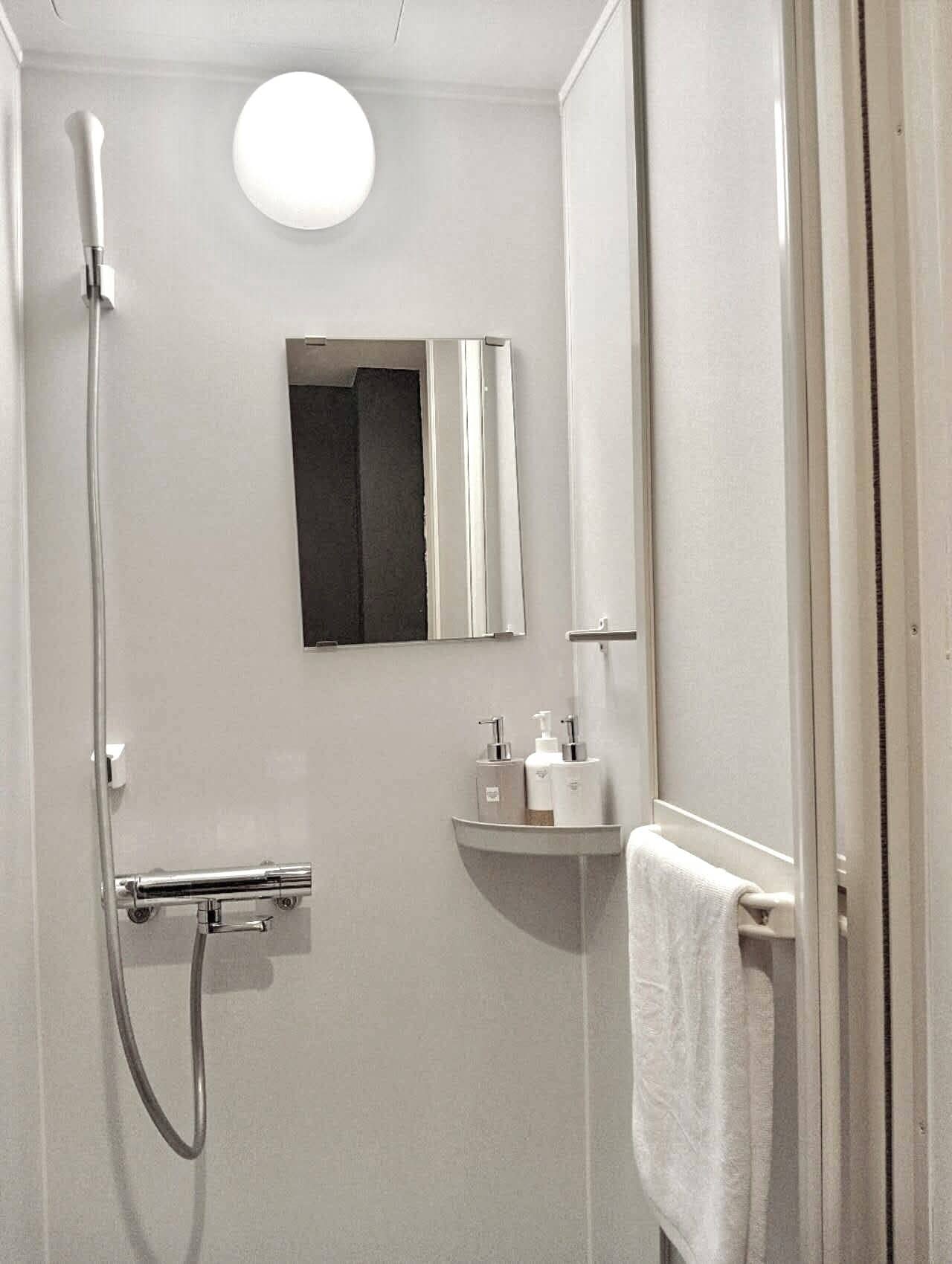 Een douche, een haardroger, pantoffels, handdoeken