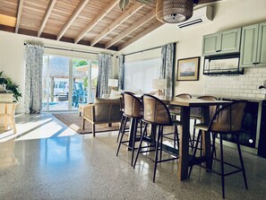 Una cocina amplia con comedor, vigas de madera en el techo y vistas al exterior.