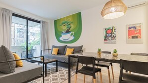 En moderne stue med sofa, spisebord, stole og kunst på væggene.