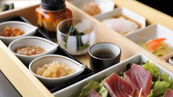 A tray with various food items including pickled vegetables, a bowl of soup, and a dish with sliced meat and salad.
