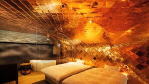 Una camera da letto moderna con due letti, una vasca da bagno e un tavolino.
