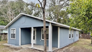 A single-story house with a garage, a front porch, and a small yard.