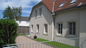Et toetagers hus med røde tegltag, en belagt indkørsel og et metalhegn.