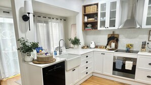 A modern kitchen with white cabinetry, a dishwasher, a sink, and a stove. - Warm Winter Escape | Fireplace and Charm (Bacchus Marsh)