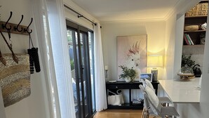 A modern kitchen with a dining area, wooden flooring, and a bench. - Warm Winter Escape | Fireplace and Charm (Bacchus Marsh)