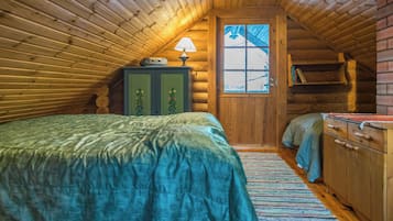 Accogliente camera da letto in legno con un letto, una cassettiera, una lampada e una finestra.