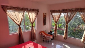 A room with a bed, a chair, a small table with candles, and curtains. - The Local Experience - Kalbas Suite (Choiseul)