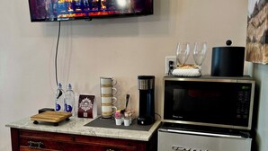 Une cuisine équipée d’un téléviseur diffusant une image de cheminée, d’une machine à café, d’un four à micro-ondes et d’un réfrigérateur.