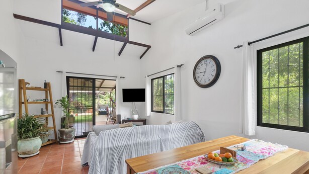 Un amplio salón con una mesa de comedor de madera, un ventanal y vistas al exterior.