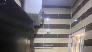 A small bathroom with a toilet, a bidet, and a window. - DE EMERITUS COURTYARD HOTEL (Abuja)