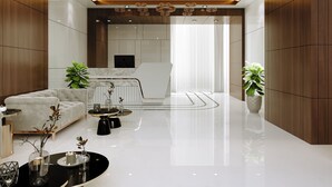 A modern living room with a sofa, coffee table, and potted plants. - Aurea by The Wallflower Hotels (Kota)