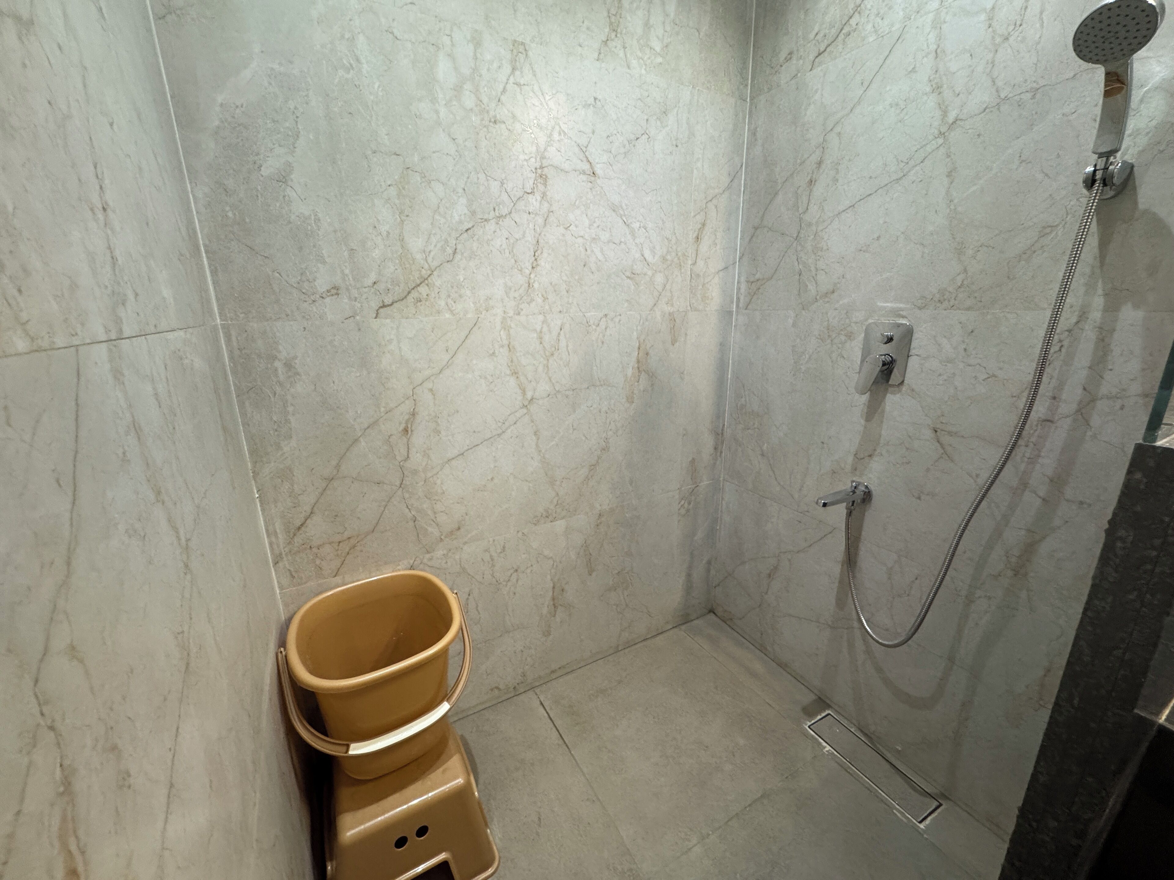 Een badkamer met een douche, toilet en wastafel.