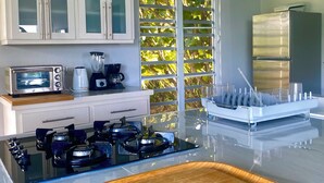 Una cocina moderna con una isla central, estufa integrada, tostadora y licuadora.