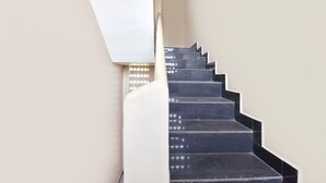 Eine Treppe mit schwarzen Stufen und weißen Wänden.
