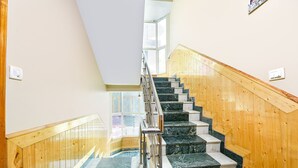 Eine Treppe mit Holzbalkonen und Marmorstufen, die zu einer höheren Etage führt.