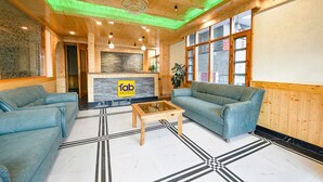 Eine Hotelhalle mit Holzwänden, einem Empfangsbereich und zwei Sofas.