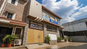 A two-story building with a sign for 'FabHotels' and another sign with text in a local language. - Fabexpress Milan Palace (Faizabad)