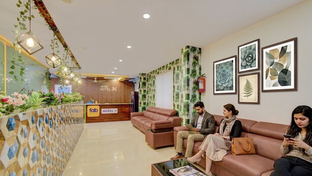 A hotel lobby with a reception desk, seating area, and artwork on the walls. - FabHotel Hitek N - Nr. Sindhu Hospital and HITEX EXHIBITION CENTER, Hitech City (Hyderabad)