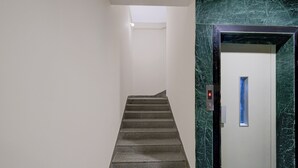 A staircase leading to a door with a marble wall. - FabHotel Hitek N - Nr. Sindhu Hospital and HITEX EXHIBITION CENTER, Hitech City (Hyderabad)