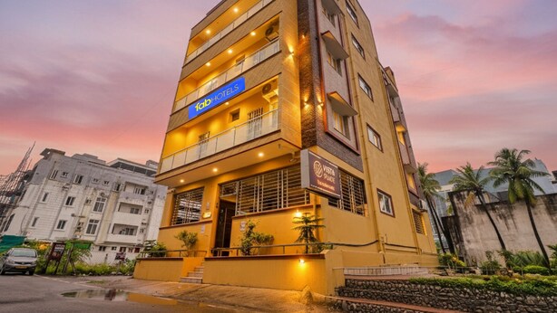 Un immeuble à plusieurs étages, doté d’une façade jaune, de balcons et d’une enseigne indiquant « Tab Hotels ».