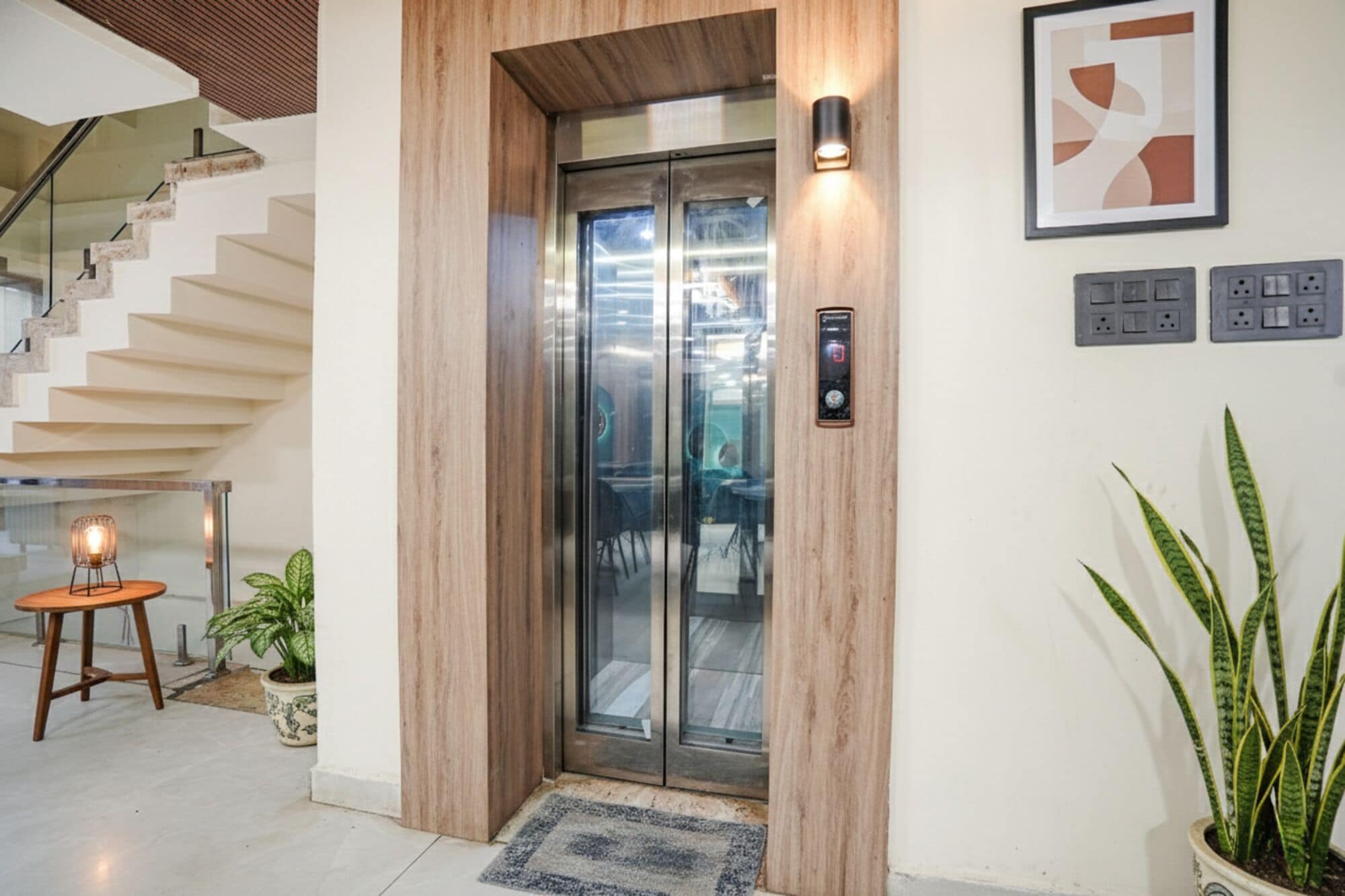 A modern elevator with a wooden finish, a digital control panel, and a glass door.